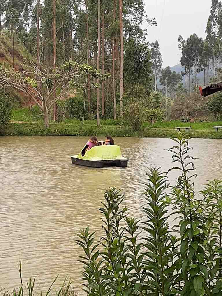 Casal aproveitando um passeio de pedalinho no lago cercado pela natureza durante uma experiência de slow travel no Parador Maritacas.
