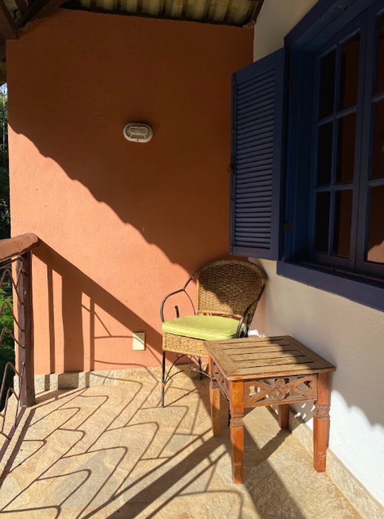 Varanda aconchegante de uma suíte do Parador Maritacas, ideal para relaxar, ler um livro e contemplar a natureza durante uma viagem slow travel.