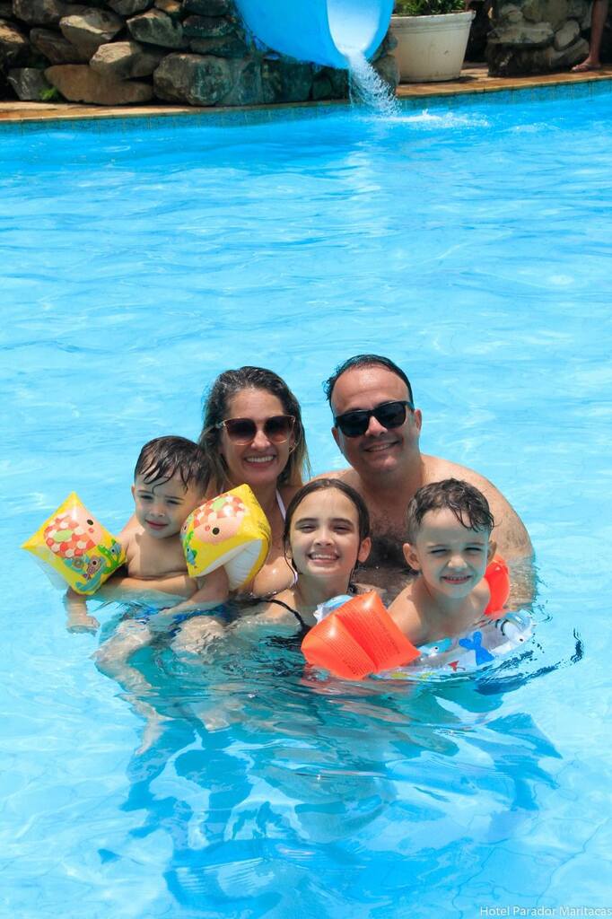 Família aproveitando a piscina durante as férias no Parador Maritacas, com crianças se divertindo em um ambiente seguro e acolhedor.