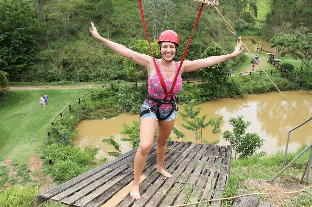 Mulher sorrindo durante atividade de aventura ao ar livre em meio à natureza do Hotel fazenda Parador Maritacas.