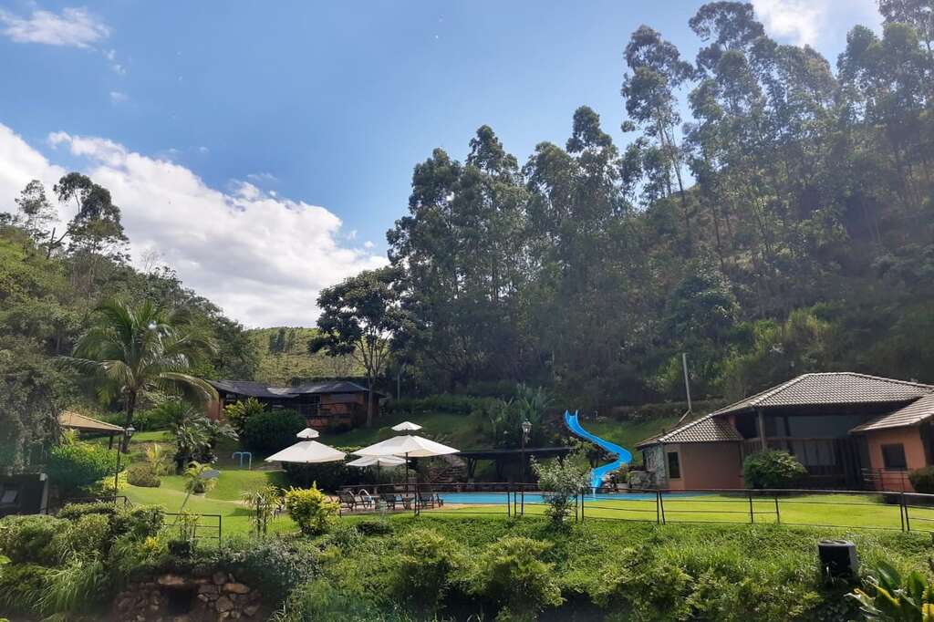 Um fim de semana no campo em meio à natureza, com áreas verdes, cercas de madeira e espaços de lazer.